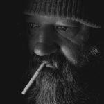 A Close-up Shot of an Elderly Man Smoking Cigarette